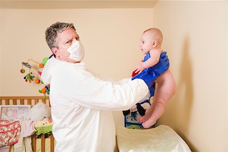 Father in decontamination suit holding baby Stock Photo - Premium Royalty-Free, Code: 673-02143246