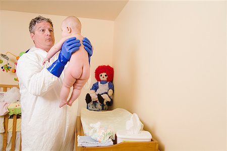 separation anxiety - Father in decontamination suit holding baby Stock Photo - Premium Royalty-Free, Code: 673-02143251