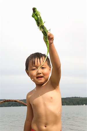 Boy holding stick with seaweed Fotografie stock - Premium Royalty-Free, Codice: 673-02143324