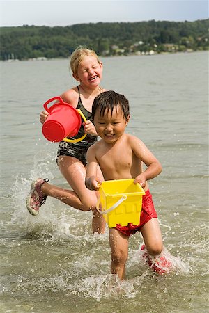 Boy and girl playing in water Stock Photo - Premium Royalty-Free, Code: 673-02143320