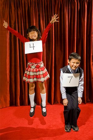 failure humour - Asian girl wearing number and cheering on stage Stock Photo - Premium Royalty-Free, Code: 673-02143348