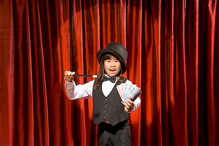 Asian girl performing magic trick on stage Foto de stock - Royalty Free Premium, Número: 673-02143352