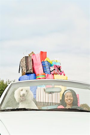 African woman in convertible with shopping bags Foto de stock - Sin royalties Premium, Código: 673-02143392