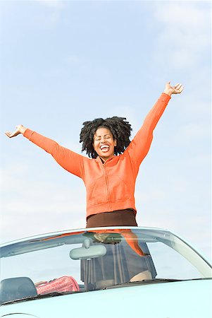 simsearch:673-02143432,k - African woman with arms raised in convertible car Stock Photo - Premium Royalty-Free, Code: 673-02143412