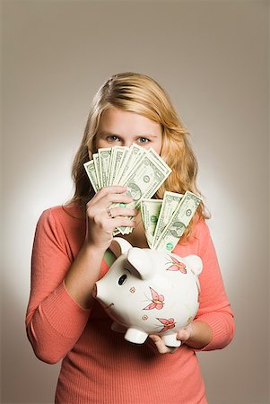 fanned out - Teenage girl holding money and piggy bank Stock Photo - Premium Royalty-Free, Code: 673-02143437