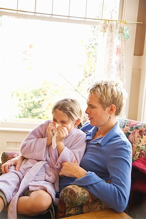 Mother watching sick daughter blow nose Stock Photo - Premium Royalty-Free, Code: 673-02143565