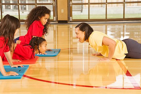 students and teacher in school gym - African female gym teacher teaching yoga to multi-ethnic students Stock Photo - Premium Royalty-Free, Code: 673-02143724