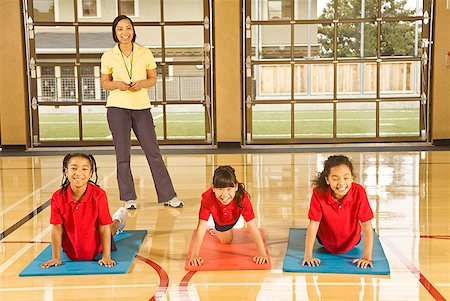 students and teacher in school gym - Multi-ethnic girls practicing yoga Stock Photo - Premium Royalty-Free, Code: 673-02143728