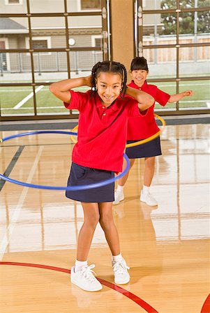 school gym exercise - Multi-ethnic girls playing with hula hoops Stock Photo - Premium Royalty-Free, Code: 673-02143721