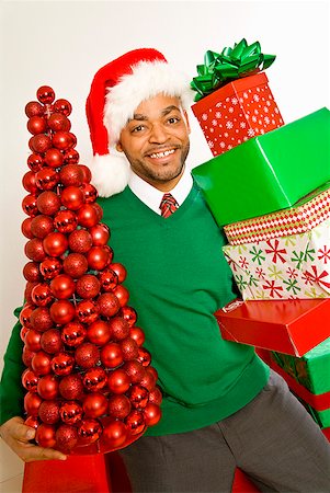 person holding stacks of paper - African man holding Christmas gifts and ornaments Stock Photo - Premium Royalty-Free, Code: 673-02143805