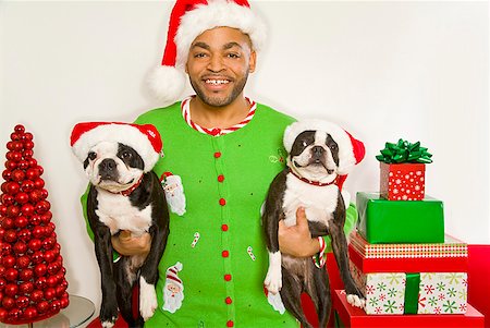 dog smile studio - African man and dogs wearing Santa Claus hats Stock Photo - Premium Royalty-Free, Code: 673-02143825