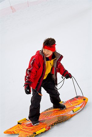 reversal - Asian girl riding on sled Stock Photo - Premium Royalty-Free, Code: 673-02143848