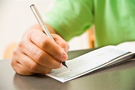 person writing in check book - Close up of African man writing check Stock Photo - Premium Royalty-Free, Code: 673-02143889