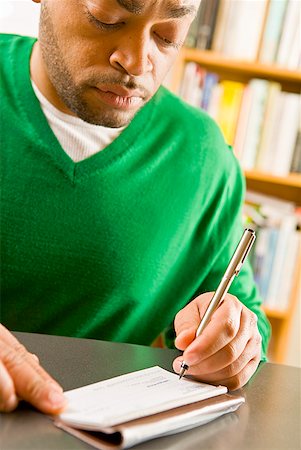 remunerating - African man writing check Stock Photo - Premium Royalty-Free, Code: 673-02143896