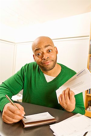 photography foolish - African man writing check Stock Photo - Premium Royalty-Free, Code: 673-02143906