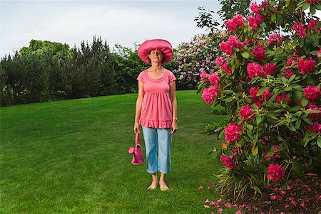 simsearch:673-02216546,k - Woman in festive pink hat standing in garden Stock Photo - Premium Royalty-Free, Code: 673-02216245