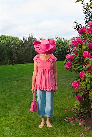 simsearch:673-02216546,k - Woman in festive pink hat standing in garden Stock Photo - Premium Royalty-Free, Code: 673-02216247