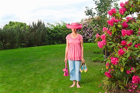 simsearch:673-02216253,k - Woman in festive pink hat standing in garden Stock Photo - Premium Royalty-Free, Code: 673-02216243