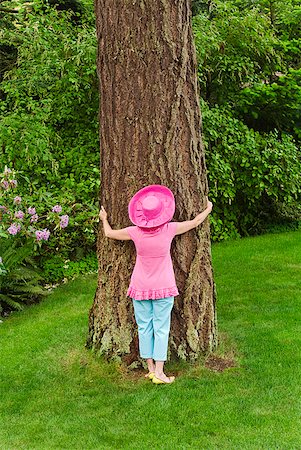 simsearch:673-02216412,k - Woman in festive pink hat hugging tree Stock Photo - Premium Royalty-Free, Code: 673-02216255