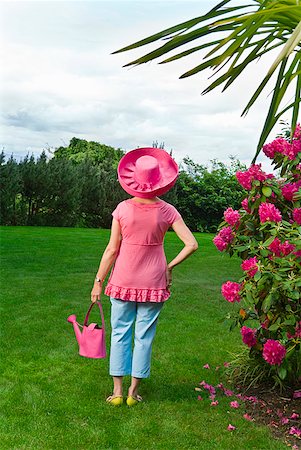 simsearch:673-02216412,k - Woman in festive pink hat standing in garden Stock Photo - Premium Royalty-Free, Code: 673-02216250