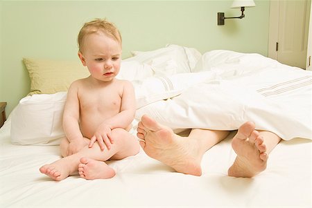 family feet in bed - Curious baby looking at mother’s feet in bed Stock Photo - Premium Royalty-Free, Code: 673-02216289