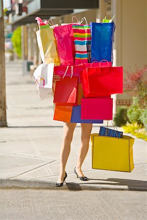 Woman balancing assorted shopping bags Stock Photo - Premium Royalty-Free, Code: 673-02216326