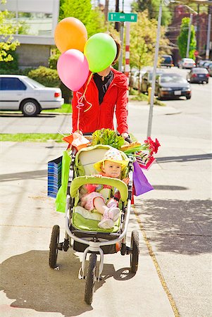 Woman pushing baby girl in stroller Foto de stock - Royalty Free Premium, Número: 673-02216331