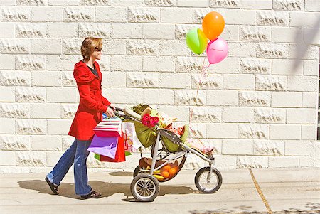 photo girl walking with balloon - Woman pushing baby girl in stroller Stock Photo - Premium Royalty-Free, Code: 673-02216333
