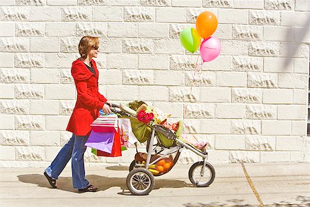 Woman pushing baby girl in stroller Foto de stock - Royalty Free Premium, Número: 673-02216333