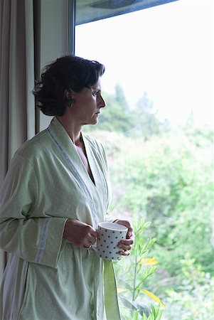 Woman drinking coffee and looking out window in the morning Stock Photo - Premium Royalty-Free, Code: 673-02216443