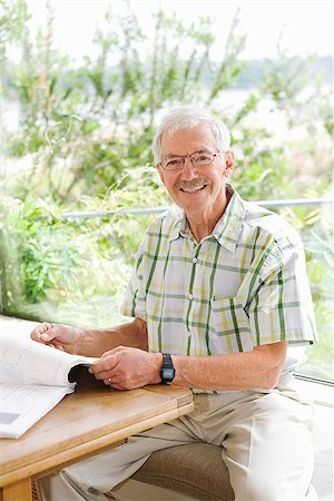 eye glasses images investing - Man reading a magazine and smiling Stock Photo - Premium Royalty-Free, Code: 673-02386338