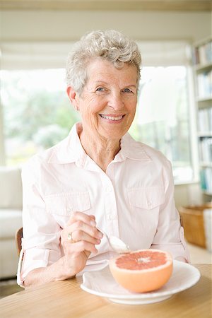Woman eating a grapefruit Stock Photo - Premium Royalty-Free, Code: 673-02386339