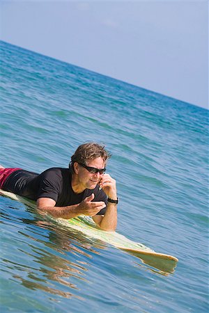 surfboard mobile - Man surfing and talking on the phone Stock Photo - Premium Royalty-Free, Code: 673-02386399