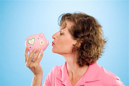 piggy bank hand - Woman kissing a piggy bank Stock Photo - Premium Royalty-Free, Code: 673-02386393