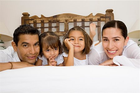 simsearch:673-02386480,k - Parents avec leurs enfants, allongé sur le lit Photographie de stock - Premium Libres de Droits, Code: 673-02386479