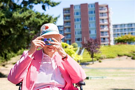 senior wheelchair outside - Woman photographing with a digital camera in a garden Stock Photo - Premium Royalty-Free, Code: 673-02386547