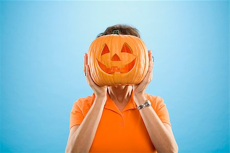 disguise - Woman covering her face with a Jack O' Lantern Stock Photo - Premium Royalty-Free, Code: 673-02386624