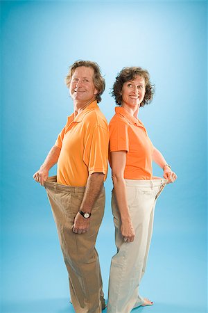 Man and a woman wearing loose pants to show their weight loss Stock Photo - Premium Royalty-Free, Code: 673-02386627