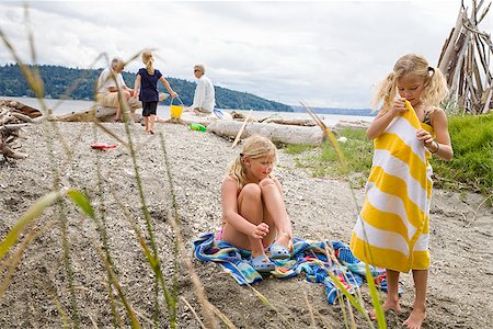 senior woman swimsuit sitting - Two girls with their family on the beach Stock Photo - Premium Royalty-Free, Code: 673-02386673