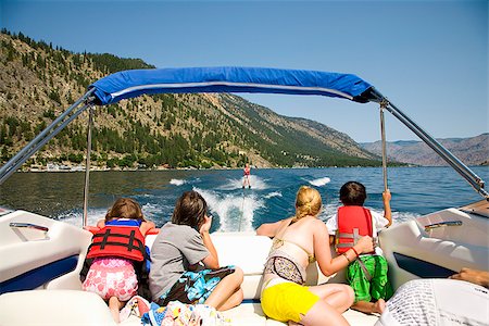 family interracial - Family in a motorboat and looking at a person waterskiing, Lake Chelan, Washington State, USA Stock Photo - Premium Royalty-Free, Code: 673-02386700