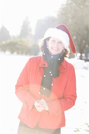 snow glare - Femme souriante dans un parc, coiffé d'un chapeau de Noël Photographie de stock - Premium Libres de Droits, Code: 673-02801234