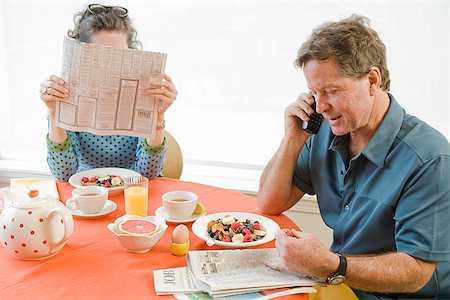 Couple having breakfast and checking newspaper classifieds Foto de stock - Sin royalties Premium, Código: 673-02801252