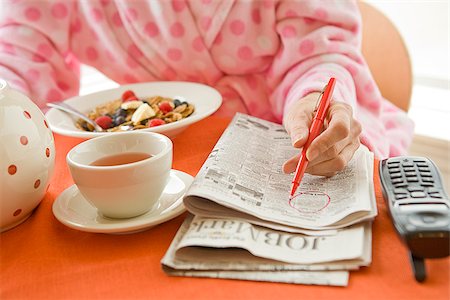 Woman having breakfast and researching classifieds Stock Photo - Premium Royalty-Free, Code: 673-02801267