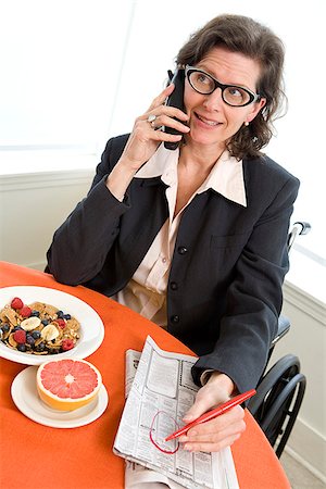 Woman in a wheelchair at breakfast talking on phone Foto de stock - Sin royalties Premium, Código: 673-02801286