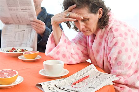 stress coffee - Tired woman with her husband at breakfast looking at classifieds Stock Photo - Premium Royalty-Free, Code: 673-02801281