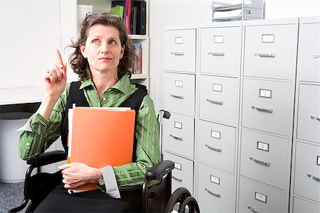 record - Woman in wheelchair holding files Stock Photo - Premium Royalty-Free, Code: 673-02801319