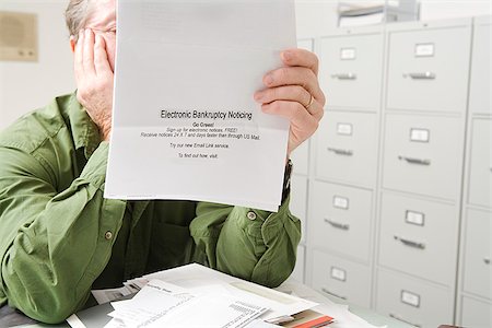 Homme désemparé avec avis de faillite Photographie de stock - Premium Libres de Droits, Code: 673-02801335