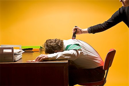 Man in office being stabbed in the back Fotografie stock - Premium Royalty-Free, Codice: 673-02801404