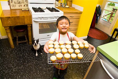 dog in kitchen - Young boy making cupcakes Stock Photo - Premium Royalty-Free, Code: 673-03005568
