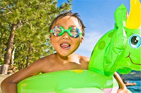 boy with dragon floatie and goggles Stock Photo - Premium Royalty-Free, Code: 673-03405742